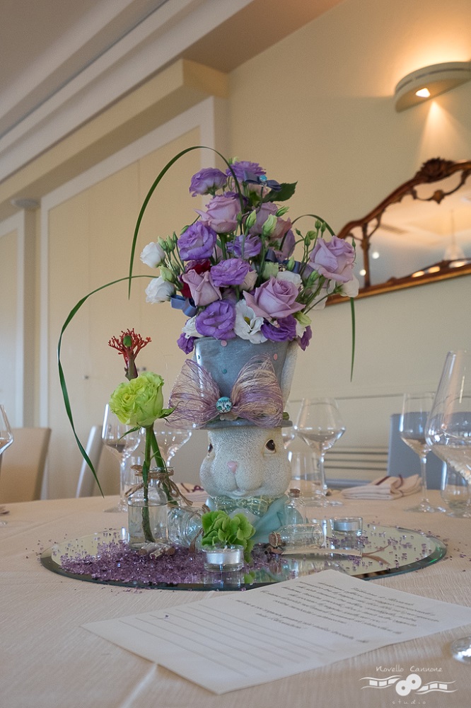 A centerpiece inspired by Alice in Wonderland, by Lewis Carroll, with a white rabbit with a top hat and pink and purple roses