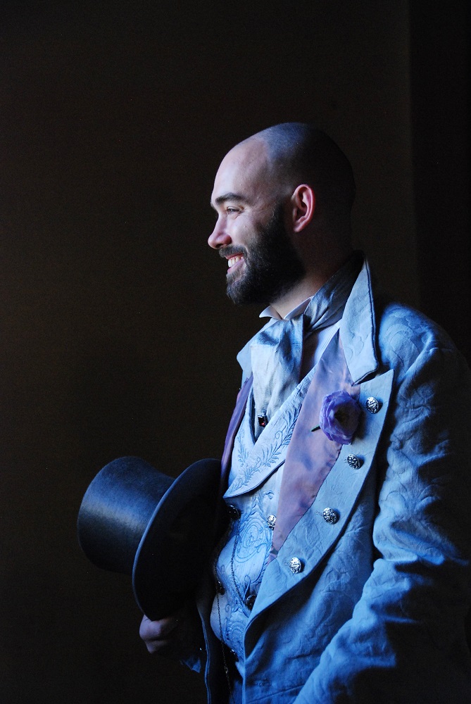 Smiling victorian groom holding an elegant top hat